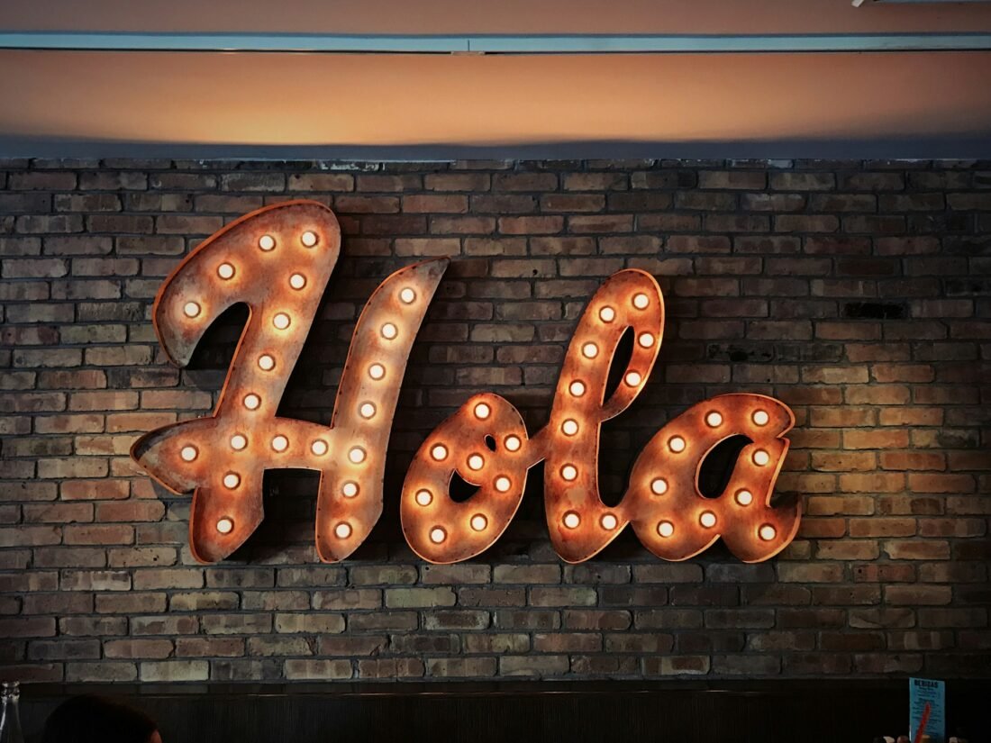 A sign with lights that says Hola