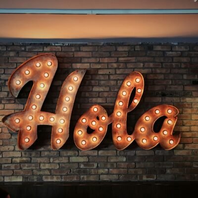 A sign with lights that says Hola